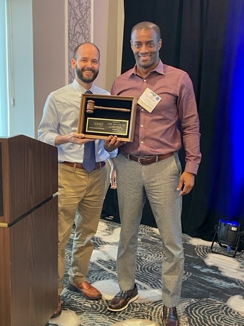 2022-2023 Richard Herring, MD (left) presents Aerick Williams, MD a plaque for his service as NCAAIS president from 2019-2021