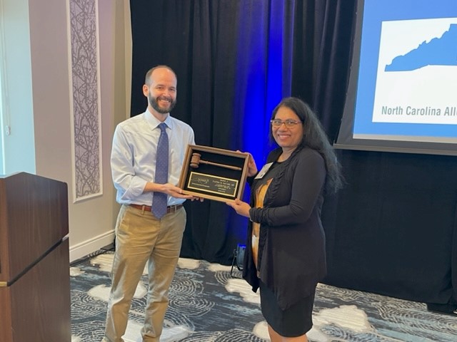 Dr. Richard Herring presents Dr. Padmaja Gayam a plaque for her service as NCAAIS president in 2021-2022